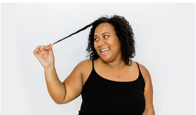 A woman confidently flaunting her hair, symbolizing acceptance and empowerment